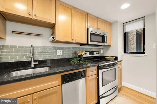 a kitchen with stainless steel appliances granite countertop a sink stove and microwave
