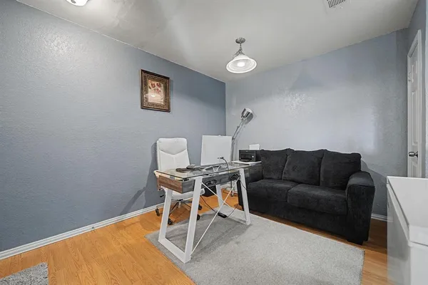 a work room with furniture and a wooden floor