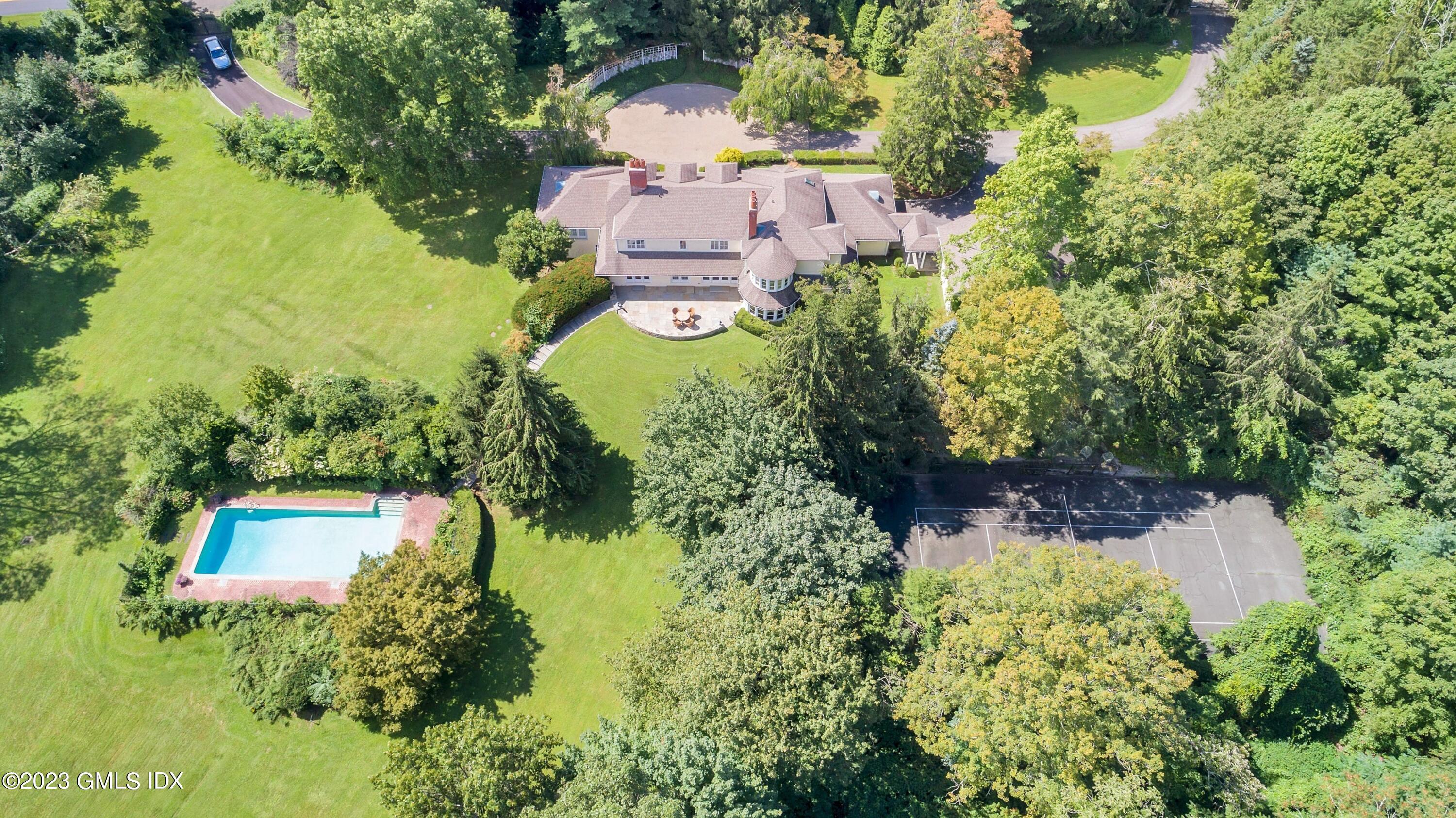 an aerial view of residential house with outdoor space and trees all around