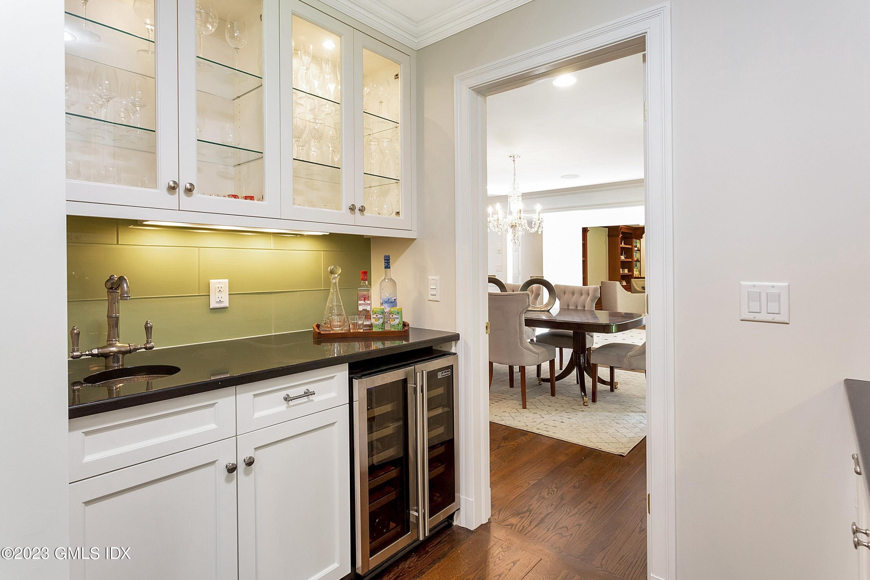 357 Round Hill Road Greenwich, CT 06831 - Photo 11 of 52 a kitchen with granite countertop a stove a sink and white cabinets with wooden floor