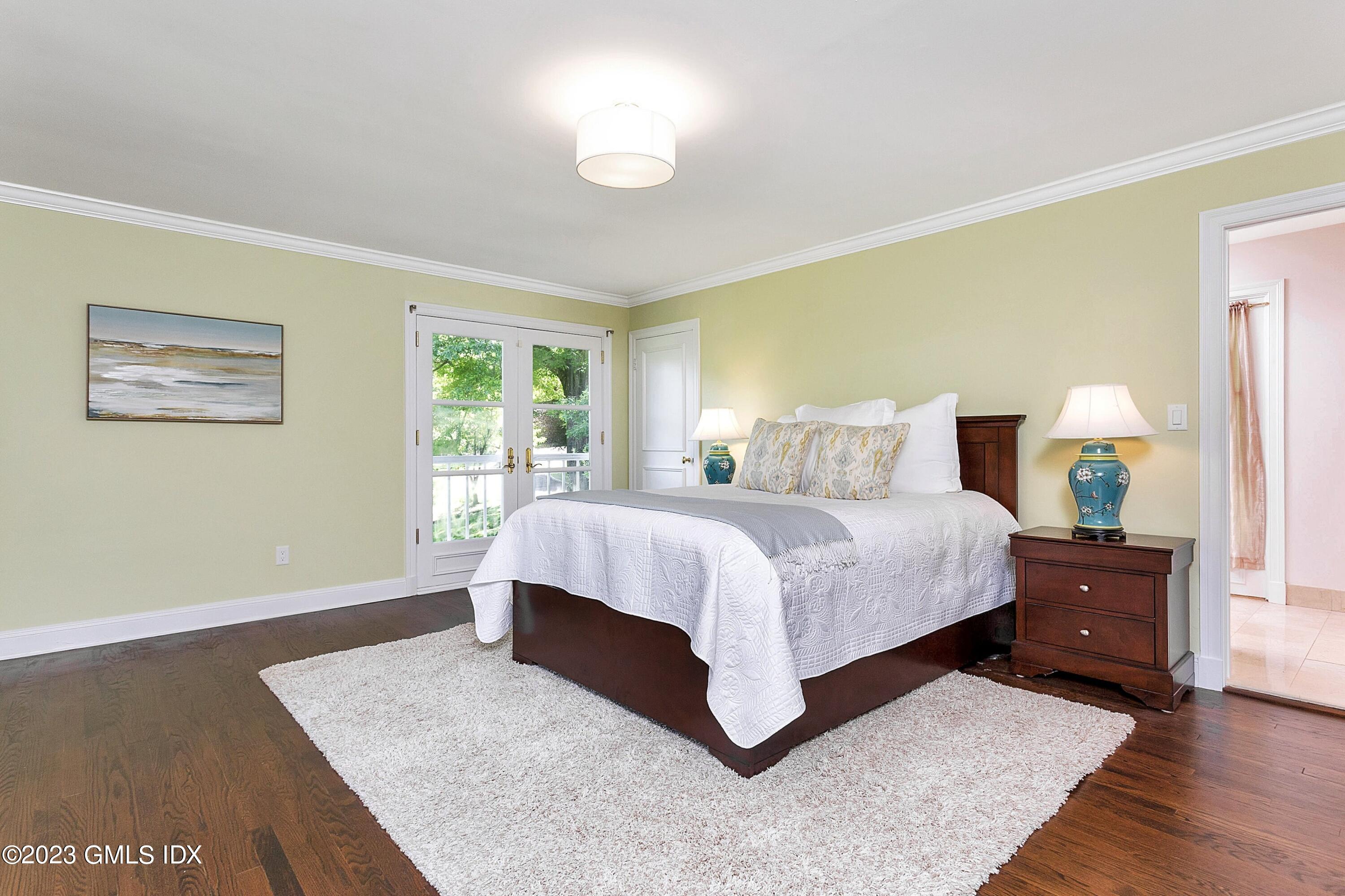 357 Round Hill Road Greenwich, CT 06831 - Photo 19 of 52 a spacious bedroom with a large bed and a window