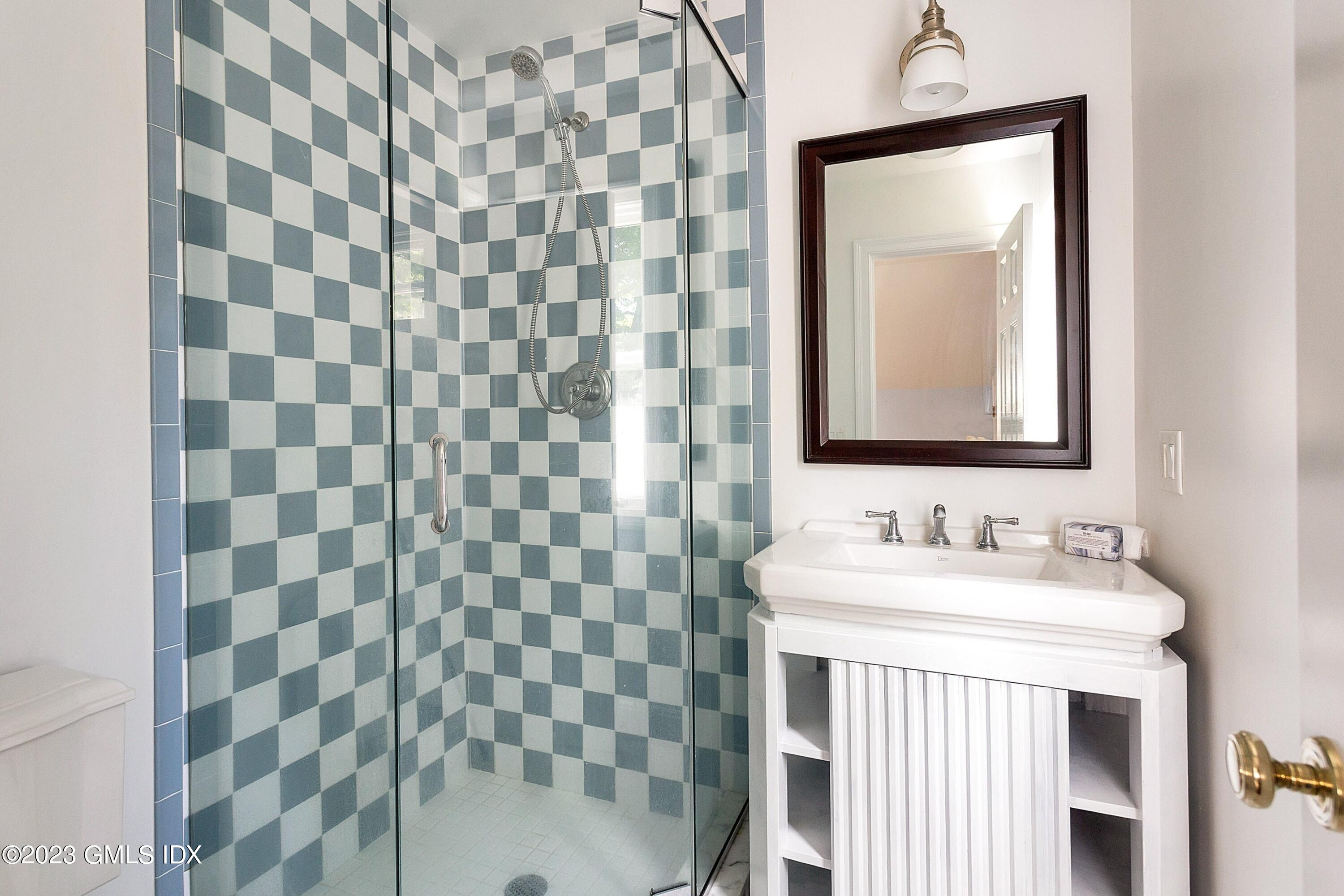 357 Round Hill Road Greenwich, CT 06831 - Photo 27 of 52 a bathroom with a sink a mirror and a shower