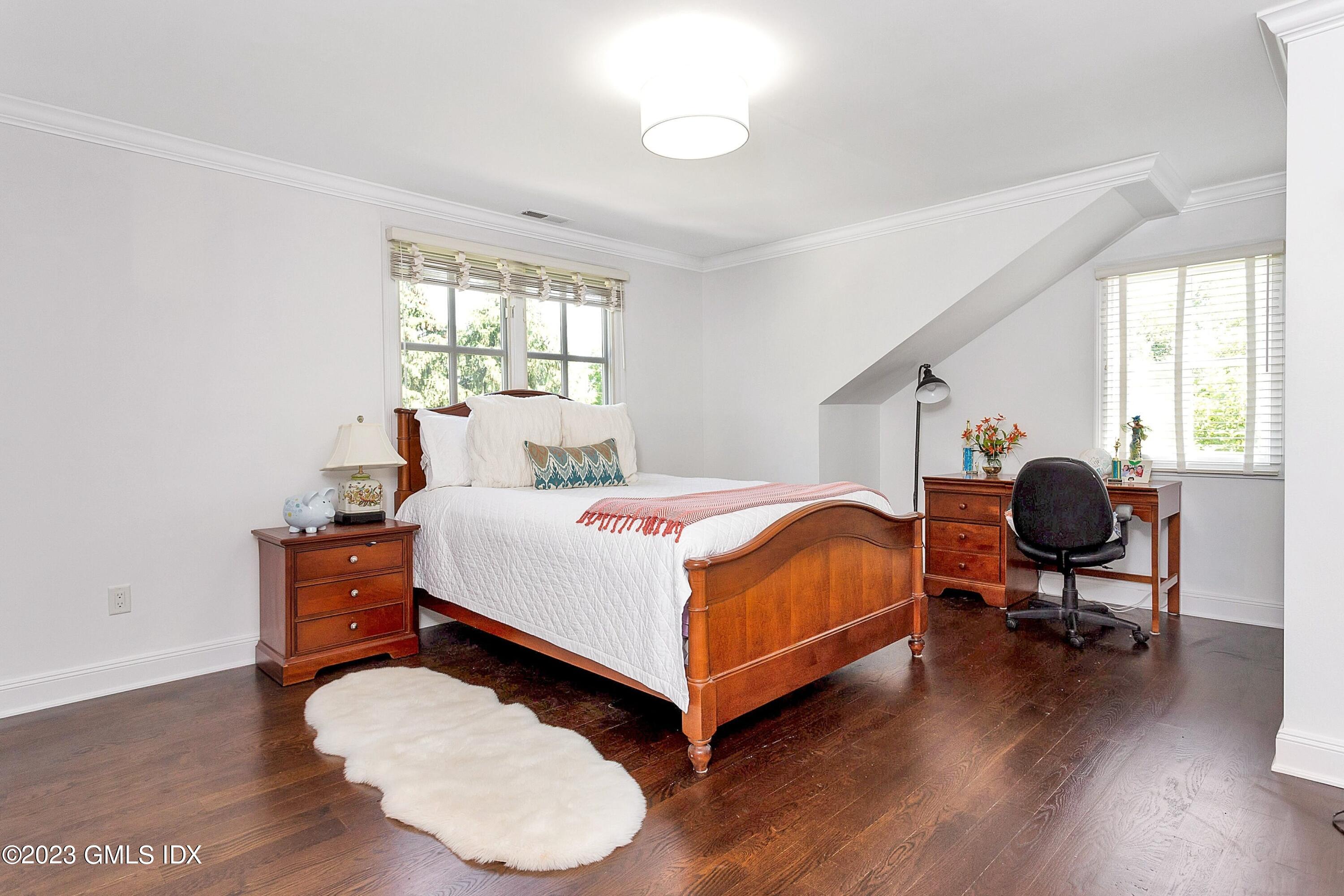 357 Round Hill Road Greenwich, CT 06831 - Photo 28 of 52 a bedroom with a bed and wooden floor