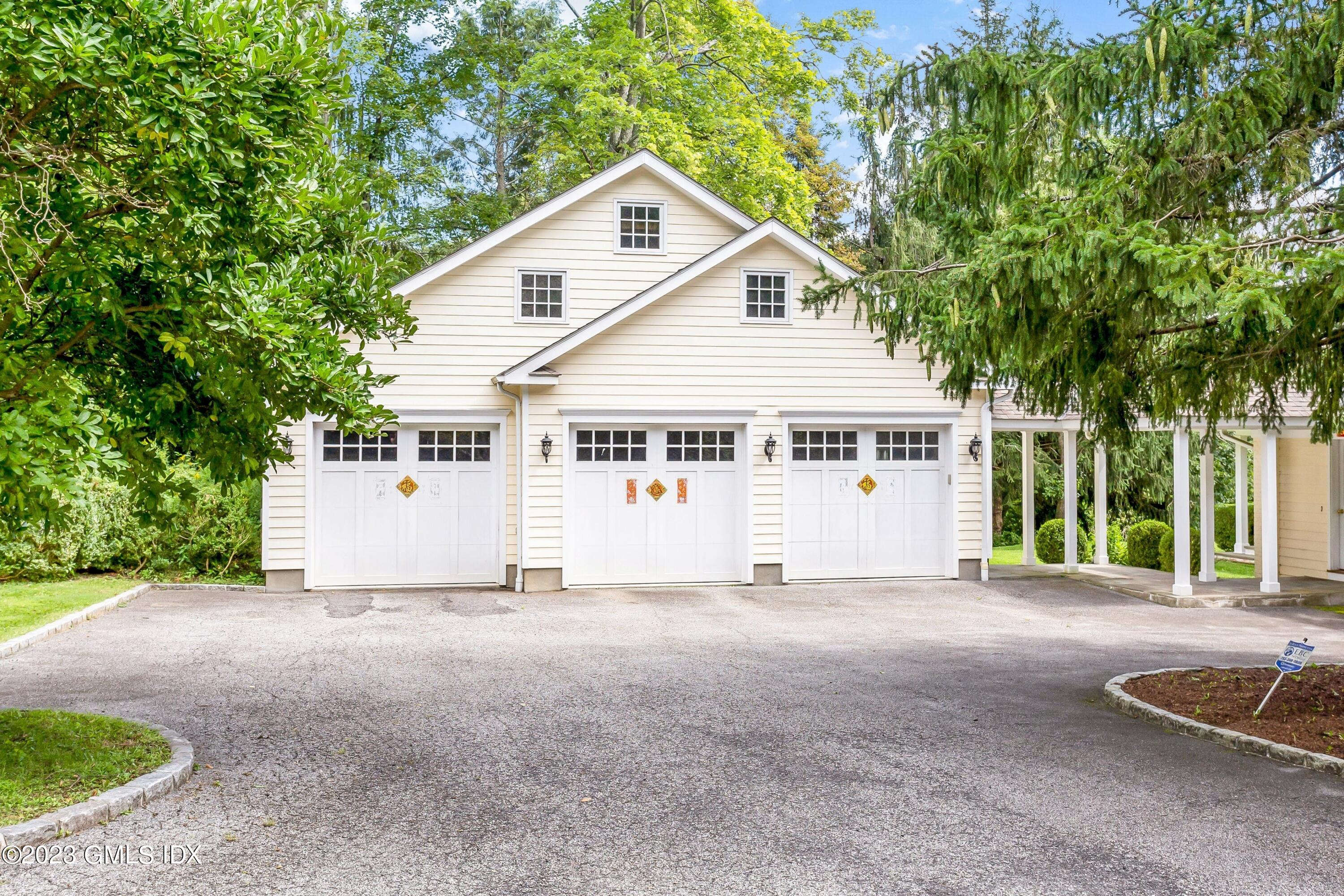 357 Round Hill Road Greenwich, CT 06831 - Photo 43 of 52 a view of a white house with a small yard and large trees