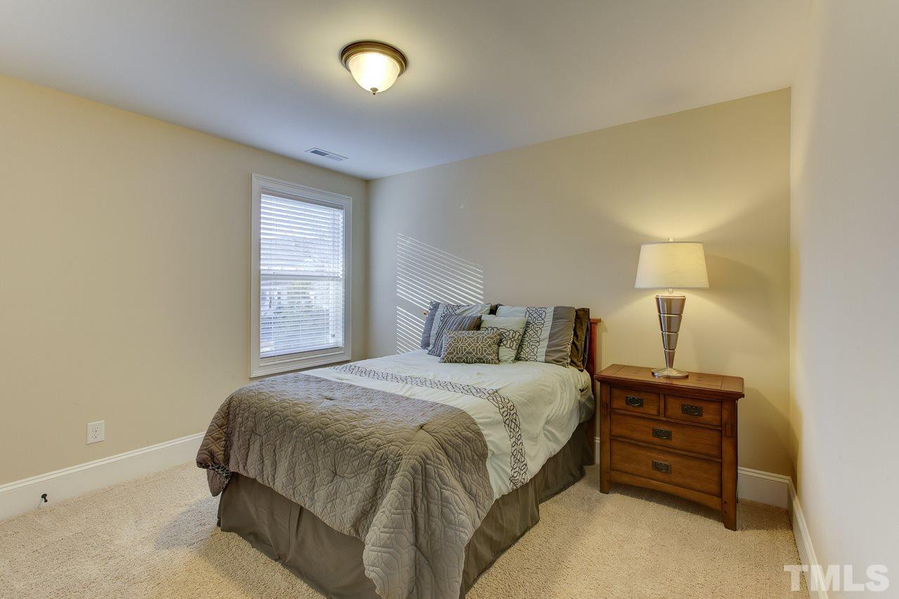 7319 Litchford Road Raleigh, NC 27615 - Photo 17 of 25 a bedroom with a bed and a lamp