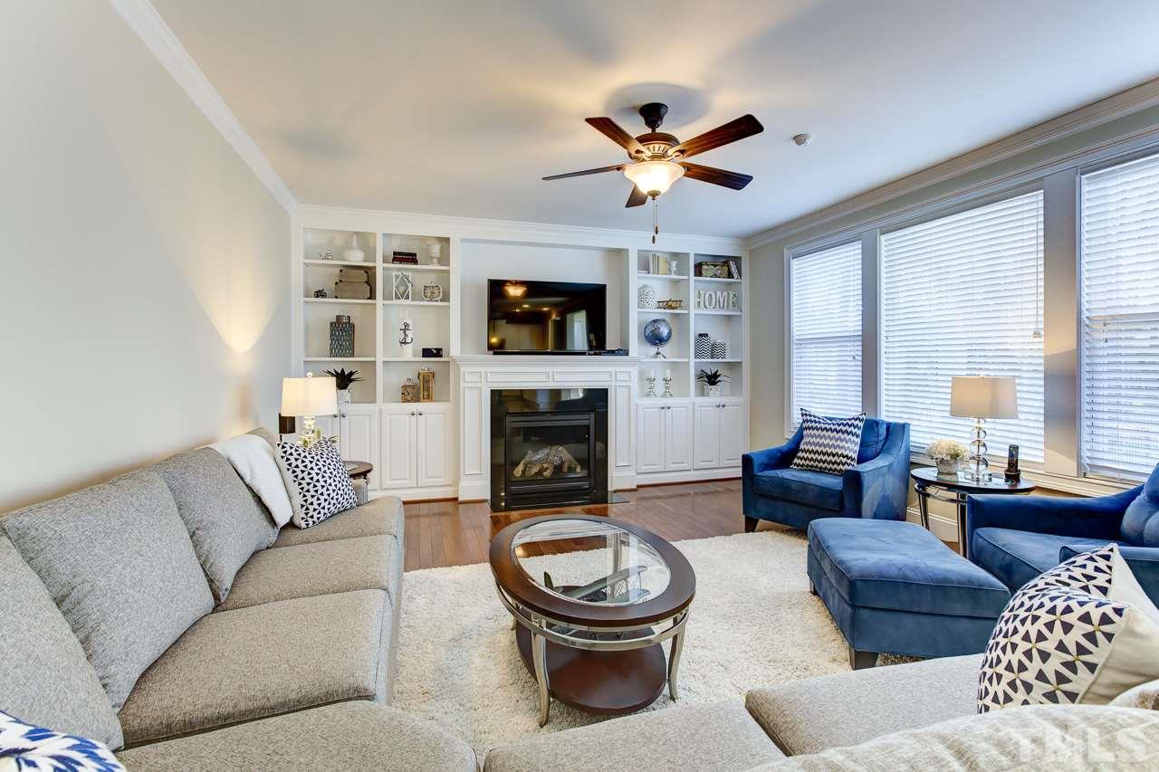 7319 Litchford Road Raleigh, NC 27615 - Photo 6 of 25 a living room with furniture a fireplace and a flat screen tv