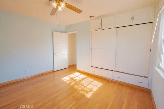 a view of an empty room with a chandelier fan