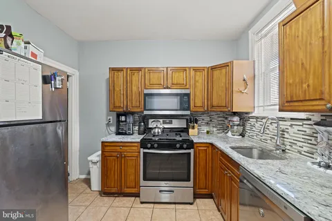 a kitchen with a stove a sink and a refrigerator