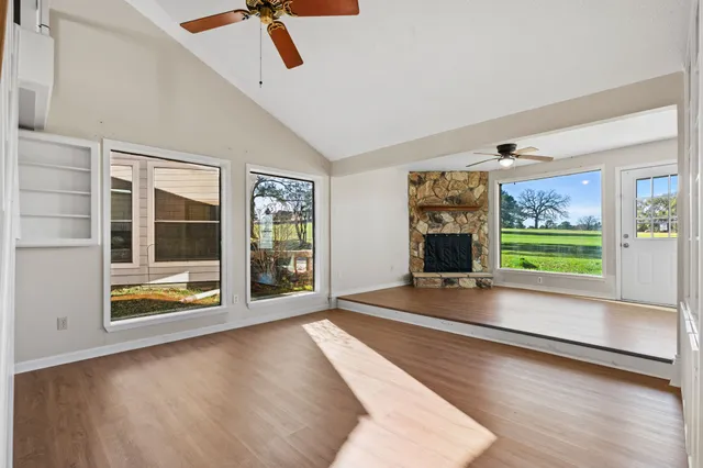 a view of an empty room with a fireplace and a window