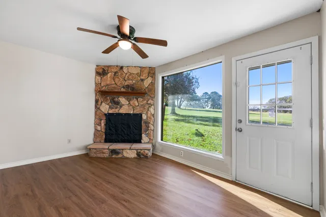 a view of room with window ceiling fan and hardwood floor