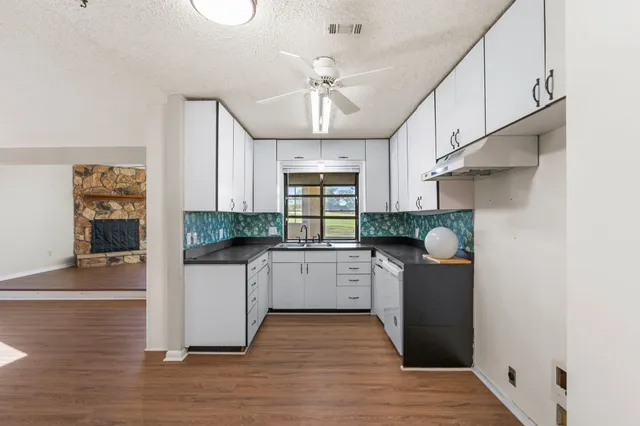a kitchen with counter top space cabinets and wooden floor