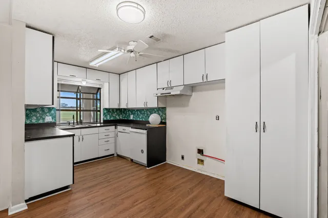 a kitchen with granite countertop white cabinets and white appliances