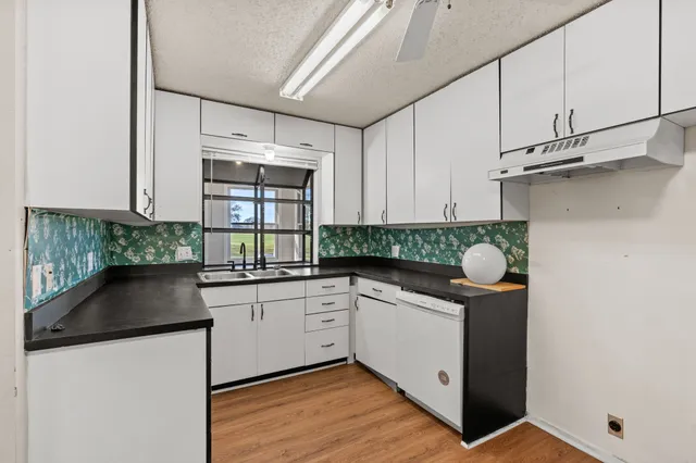 a kitchen with granite countertop white cabinets and white appliances