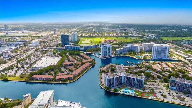 a living room with furniture a rug kitchen view and a large window