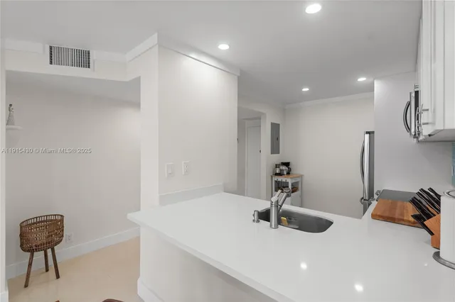 a view of a hallway with stainless steel appliances