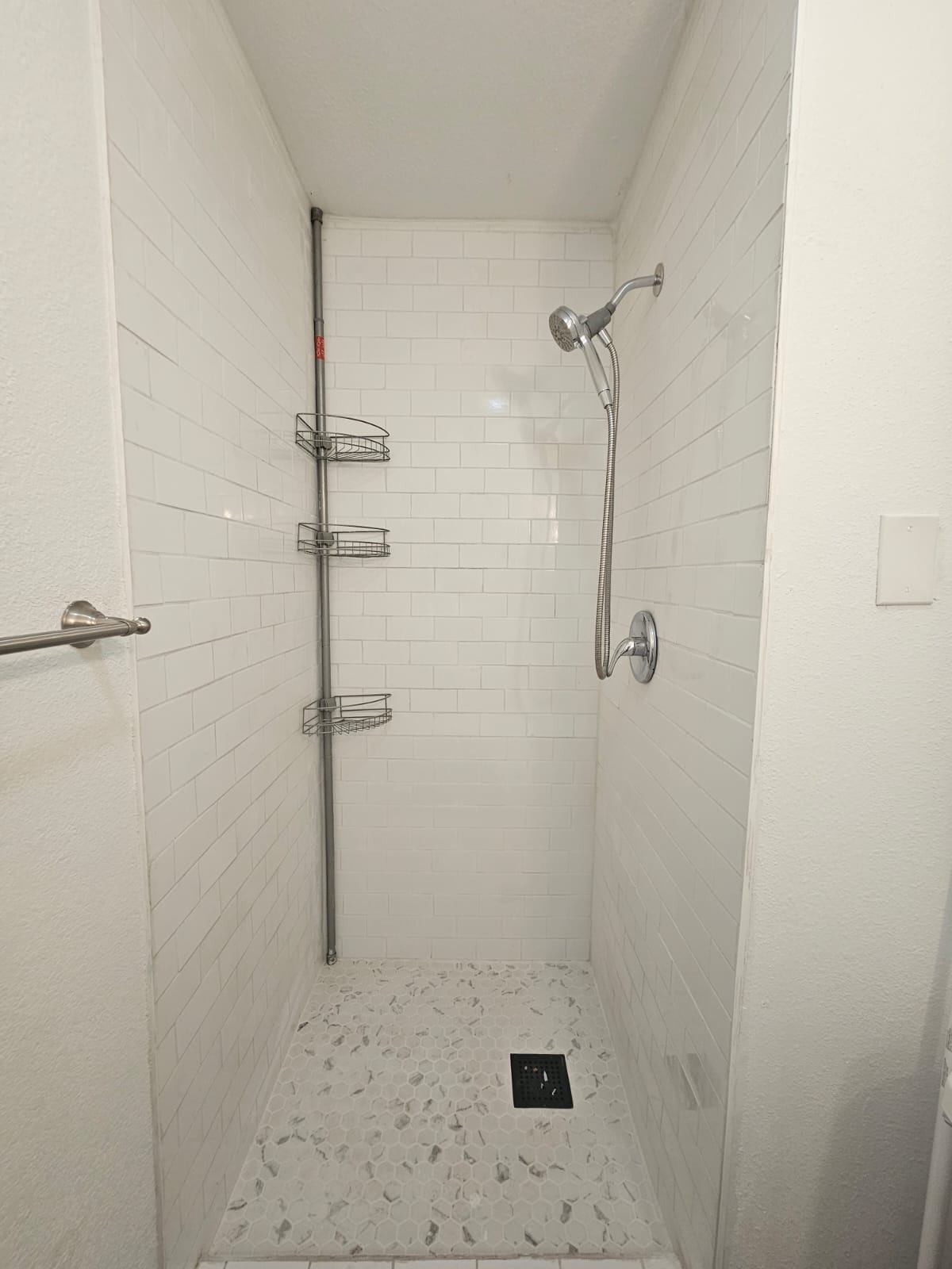 1401 Trinity Street Lockhart, TX 78644 - Photo 17 of 31 Shower stall featuring white subway tile walls and a white pebble-style floor