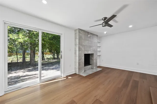 a view of empty room with wooden floor and fireplace