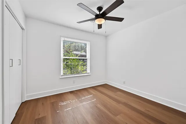 an empty room with a window and a ceiling fan