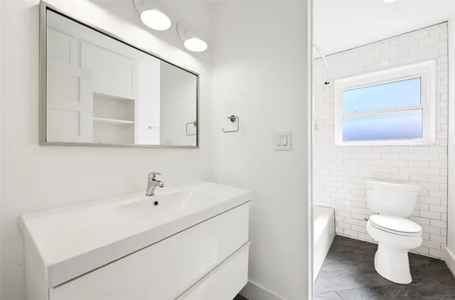 a bathroom with a sink a toilet and a mirror