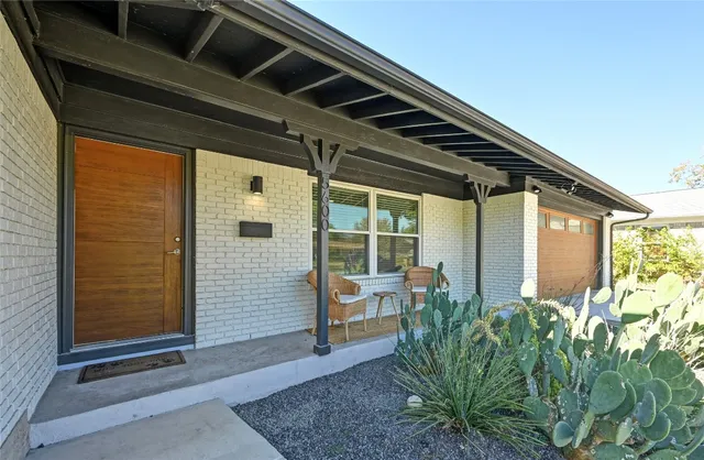 a view of a porch with chairs and potted plants