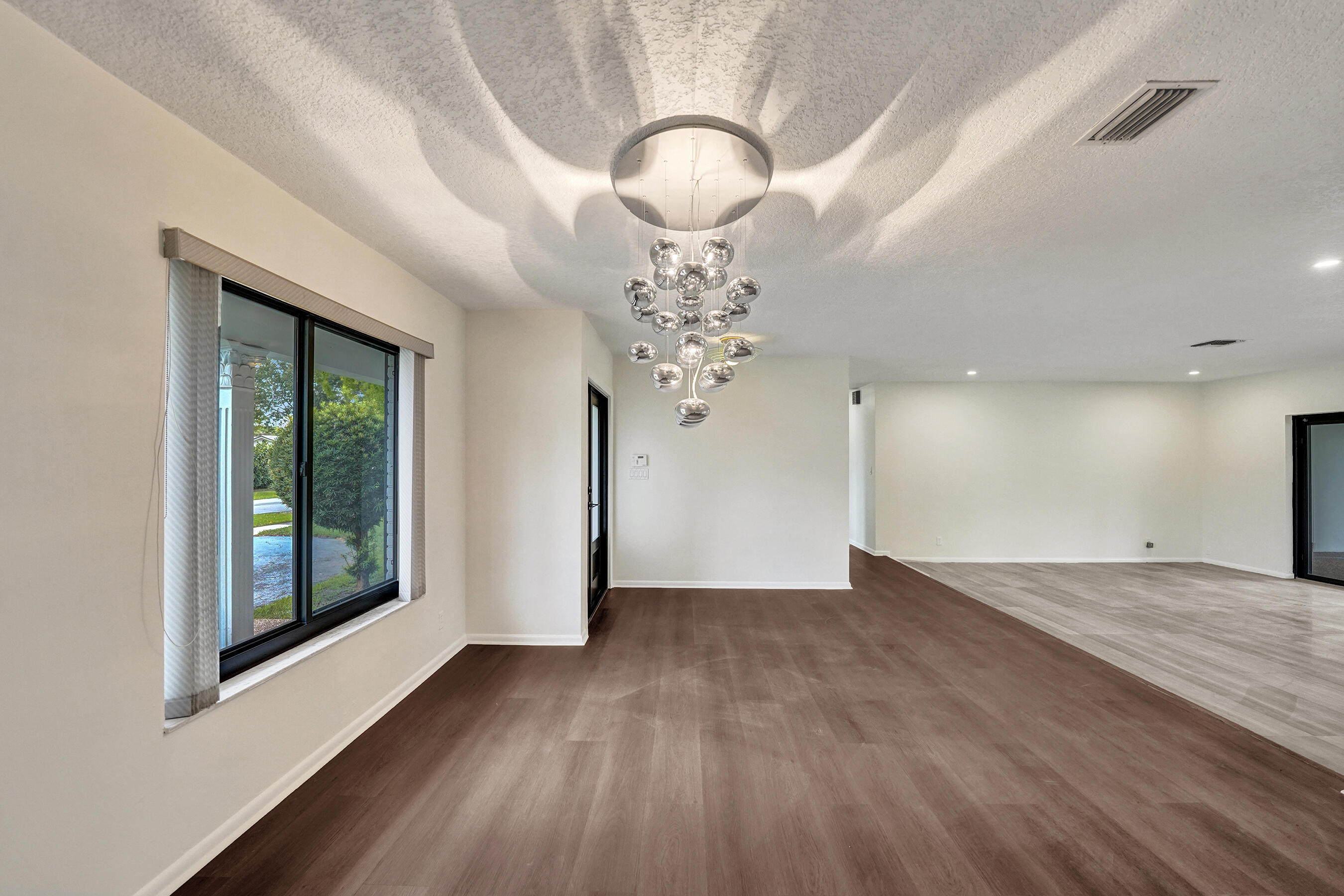 1321 Southwest 74th Terrace Plantation, FL 33317 - Photo 15 of 59 a view of a livingroom with a chandelier wooden floor and windows