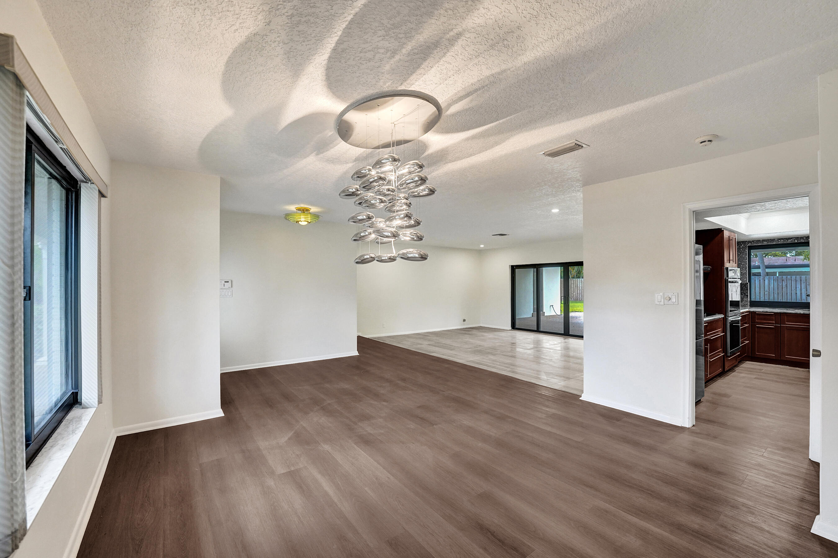 1321 Southwest 74th Terrace Plantation, FL 33317 - Photo 19 of 59 a view of a livingroom with a chandelier fan and kitchen view