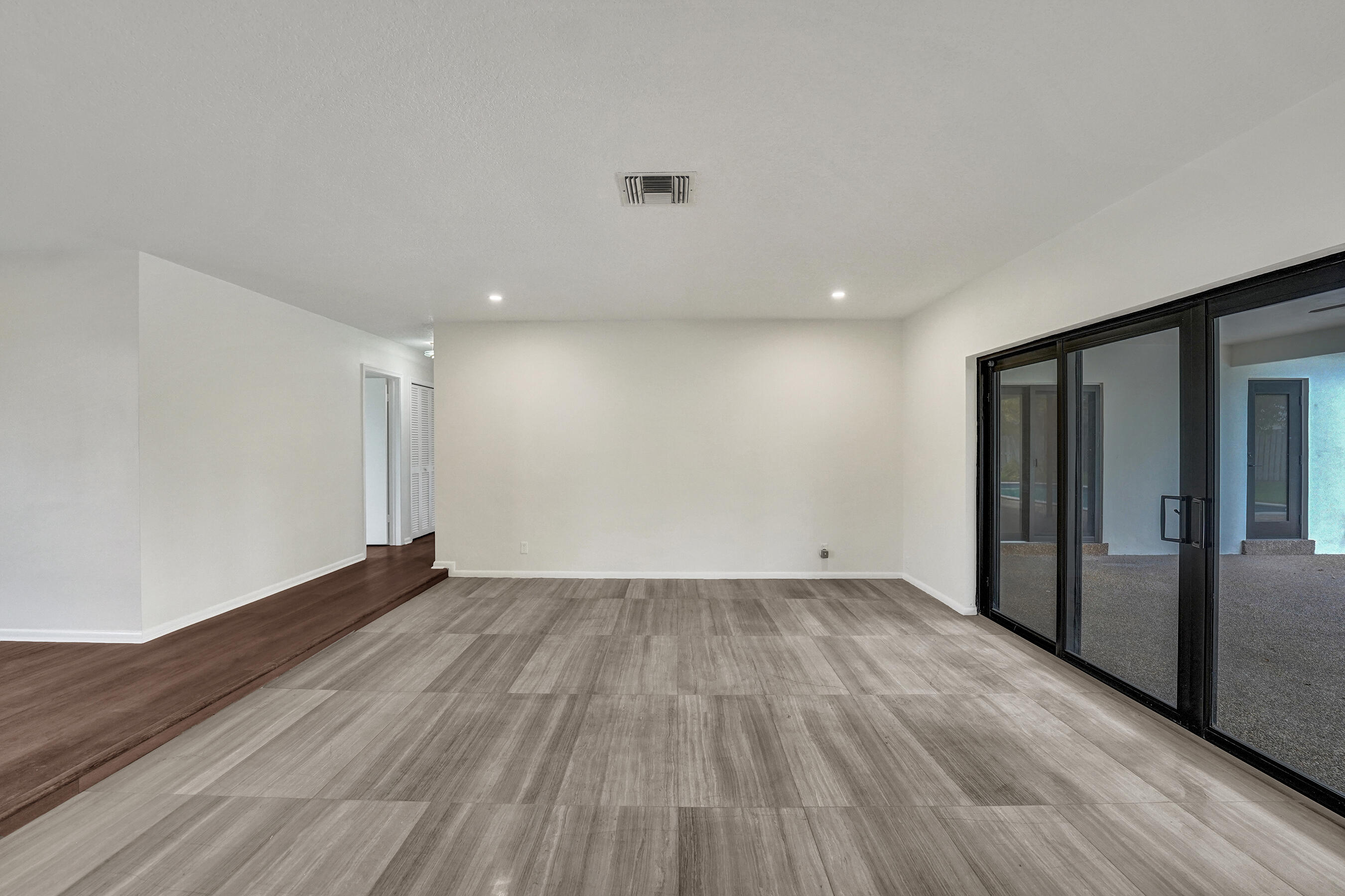 1321 Southwest 74th Terrace Plantation, FL 33317 - Photo 21 of 59 a view of an empty room with wooden floor and a window