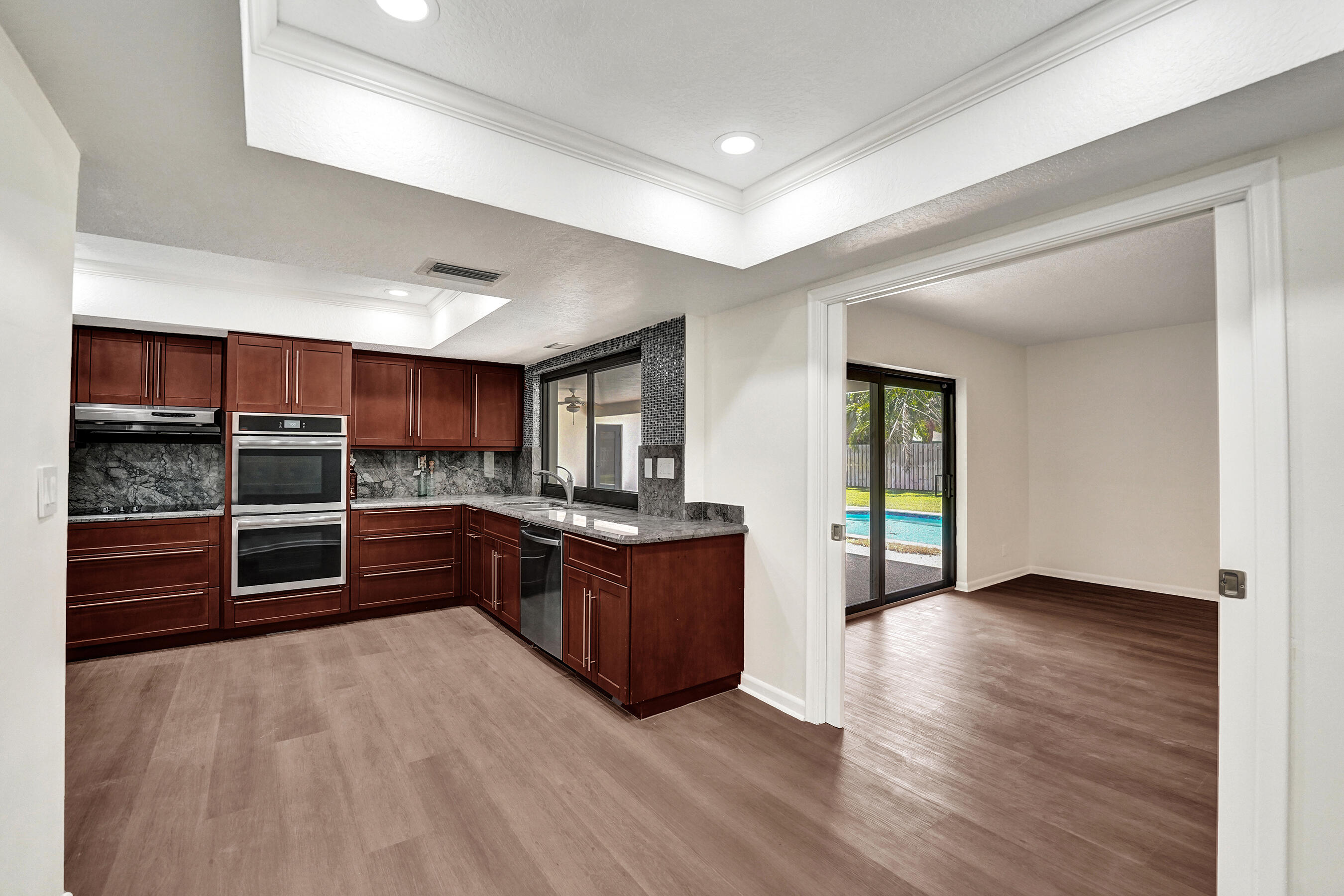 1321 Southwest 74th Terrace Plantation, FL 33317 - Photo 23 of 59 a large open kitchen with stainless steel appliances kitchen island granite countertop a large counter top and oven