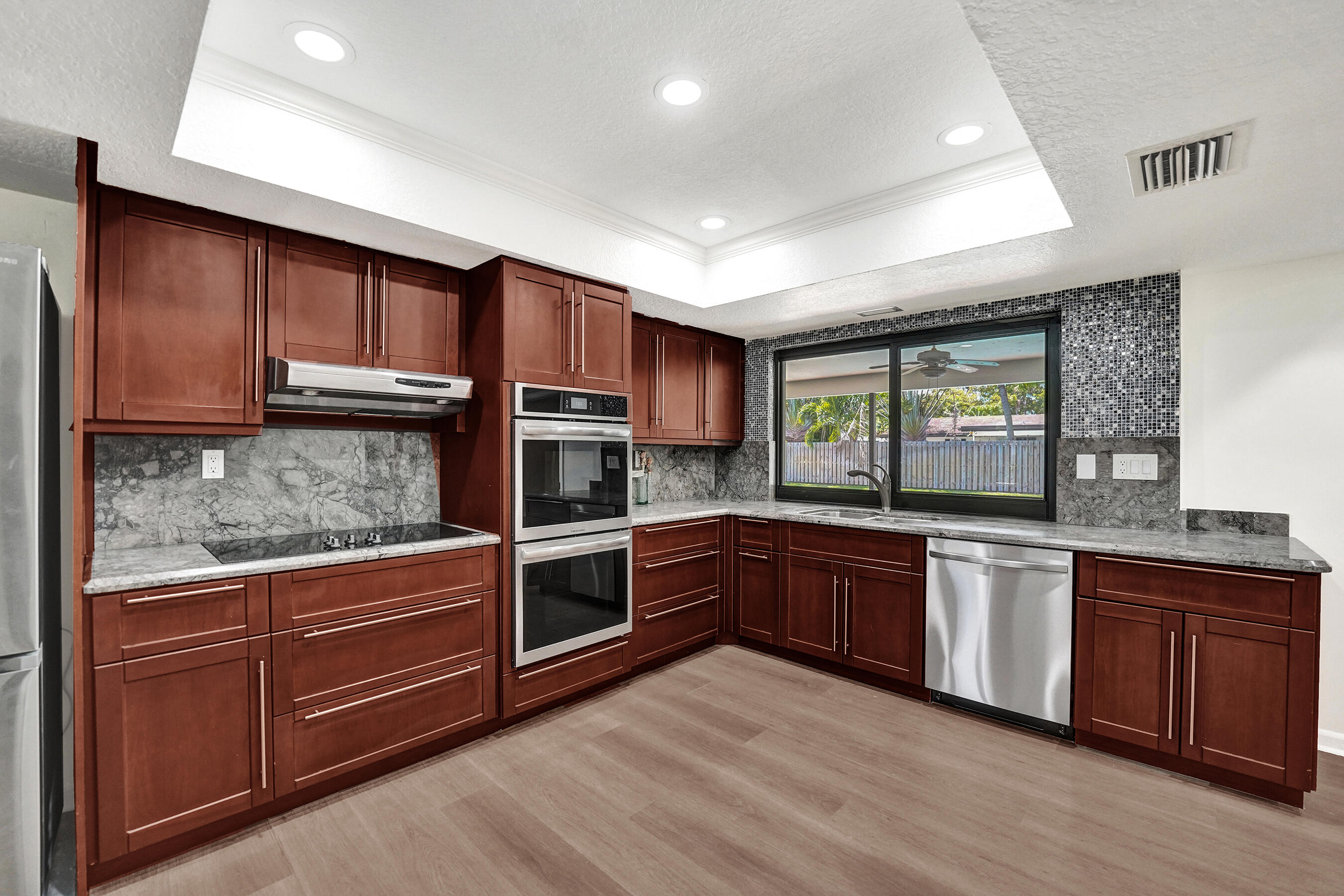 1321 Southwest 74th Terrace Plantation, FL 33317 - Photo 24 of 59 a kitchen with stainless steel appliances granite countertop wooden cabinets and a stove top oven
