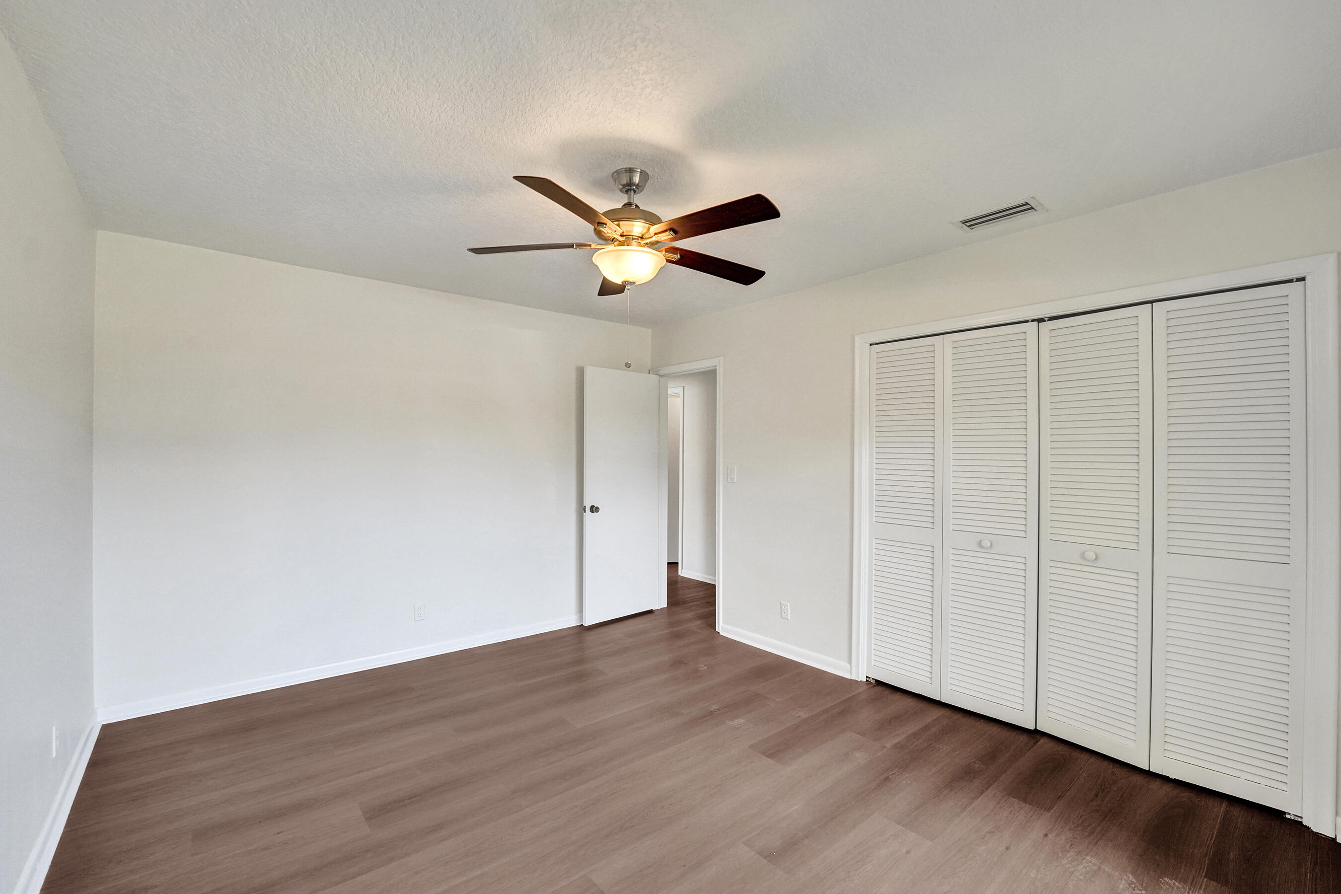 1321 Southwest 74th Terrace Plantation, FL 33317 - Photo 37 of 59 a view of an empty room with a ceiling fan and wooden floor