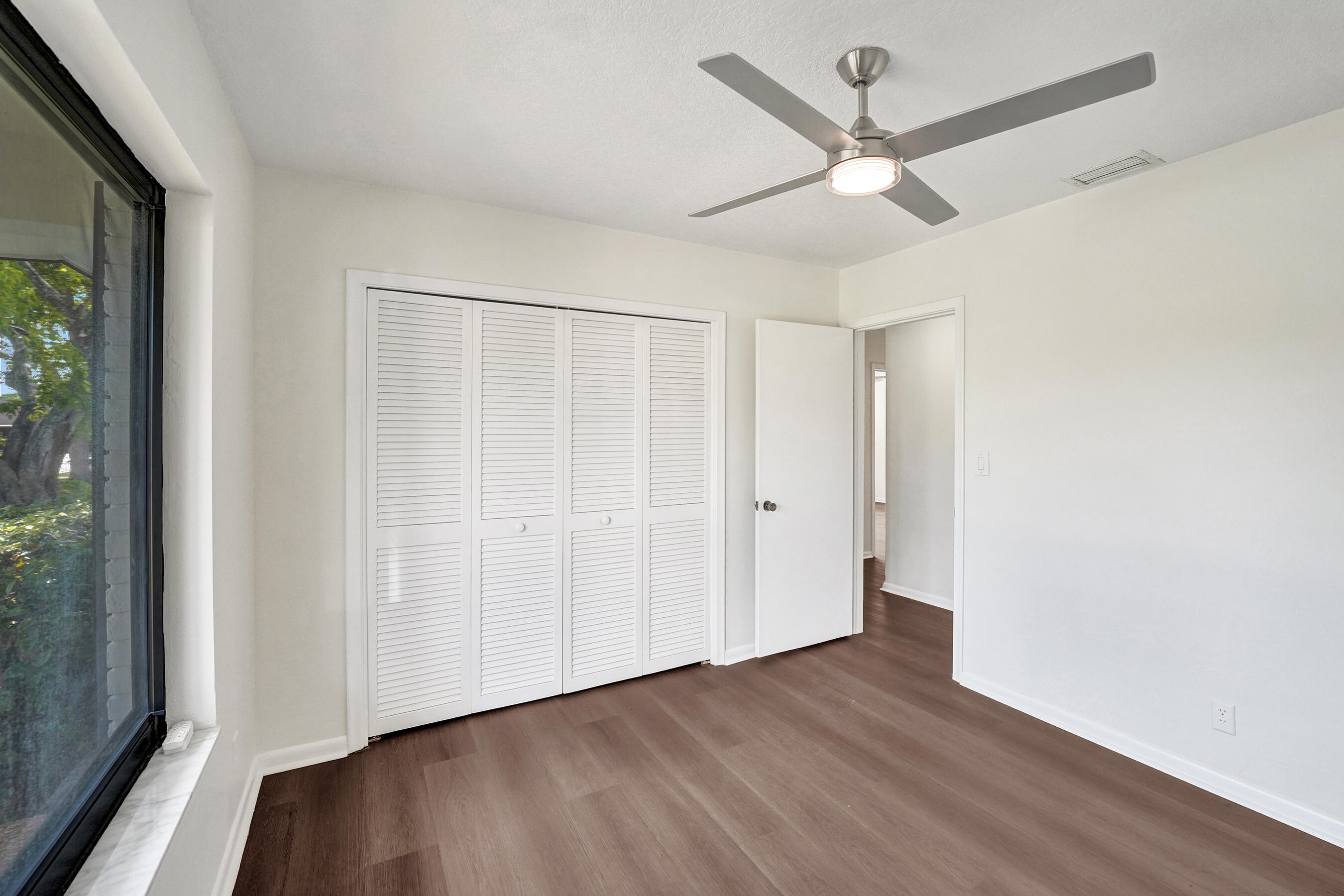 1321 Southwest 74th Terrace Plantation, FL 33317 - Photo 44 of 59 an empty room with wooden floor fan and windows