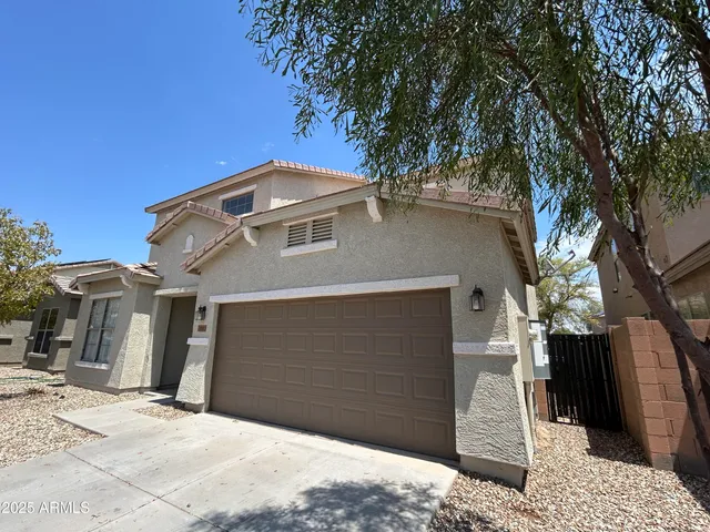 a front view of a house with a tree