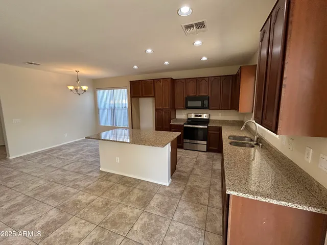 a large kitchen with stainless steel appliances granite countertop a large counter top and a stove top oven