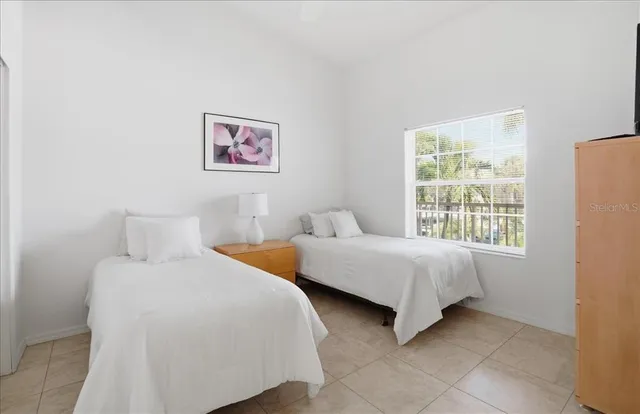 a bedroom with two beds and a window