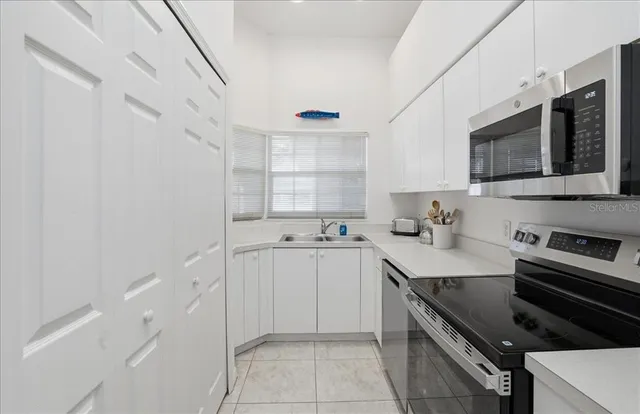 a kitchen with stainless steel appliances a sink stove and cabinets