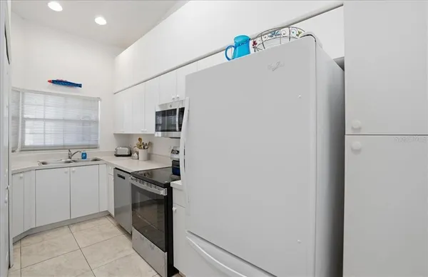 a kitchen with a sink a stove top oven and white stainless steel appliances