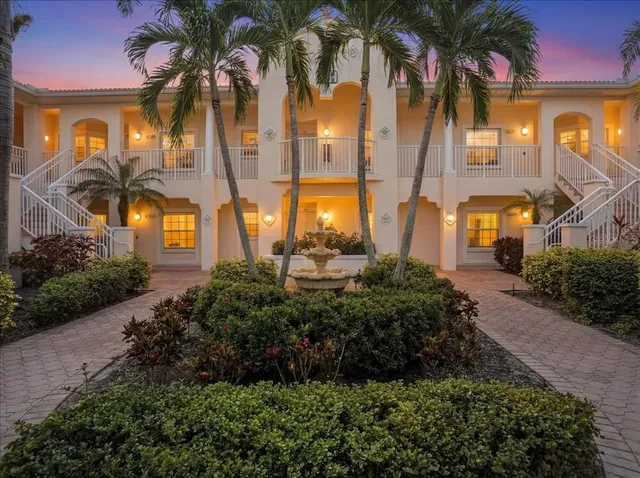 a view of a multi story residential apartment building with a yard and potted plants