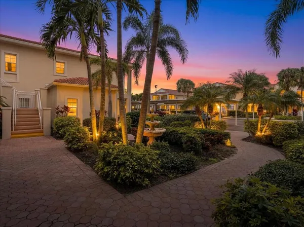 a view of a house with a yard and potted plants