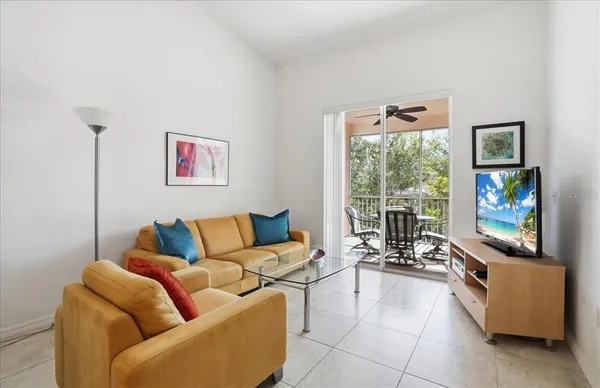 a living room with furniture a flat screen tv and a large window