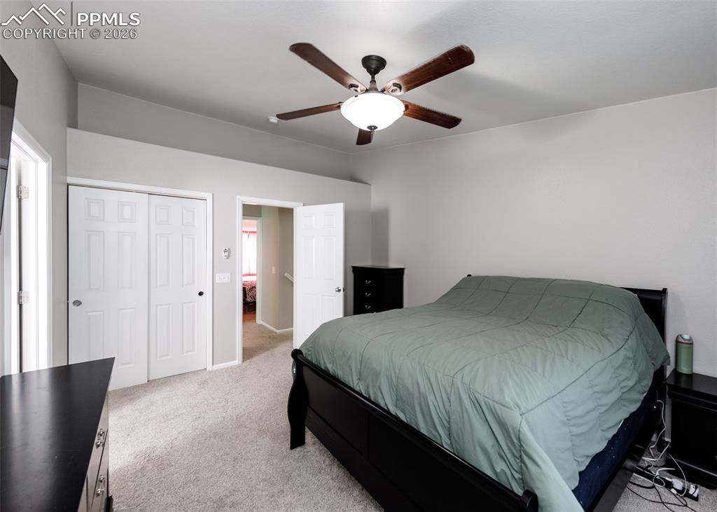 12940 Casa De Campo Road Peyton, CO 80831 - Photo 17 of 50 a bedroom with a bed and a chandelier