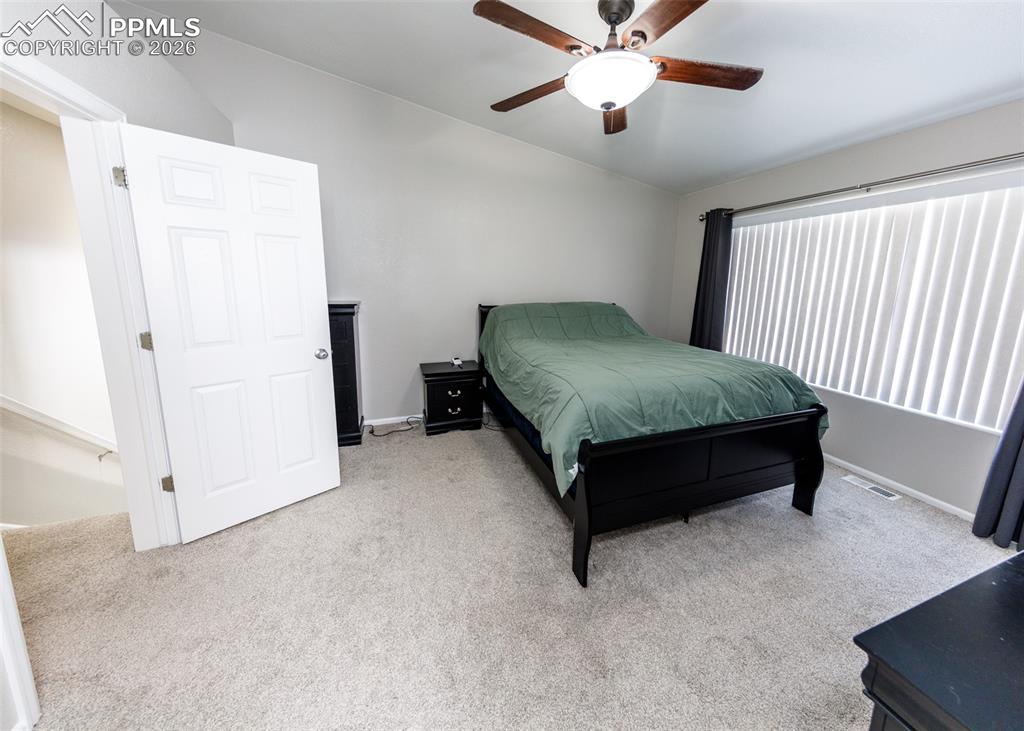 12940 Casa De Campo Road Peyton, CO 80831 - Photo 18 of 50 a bedroom with a bed and a ceiling fan