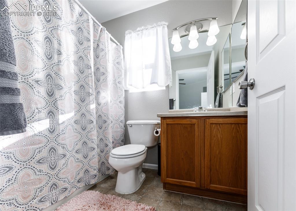 12940 Casa De Campo Road Peyton, CO 80831 - Photo 20 of 50 a bathroom with a sink a toilet and shower curtain