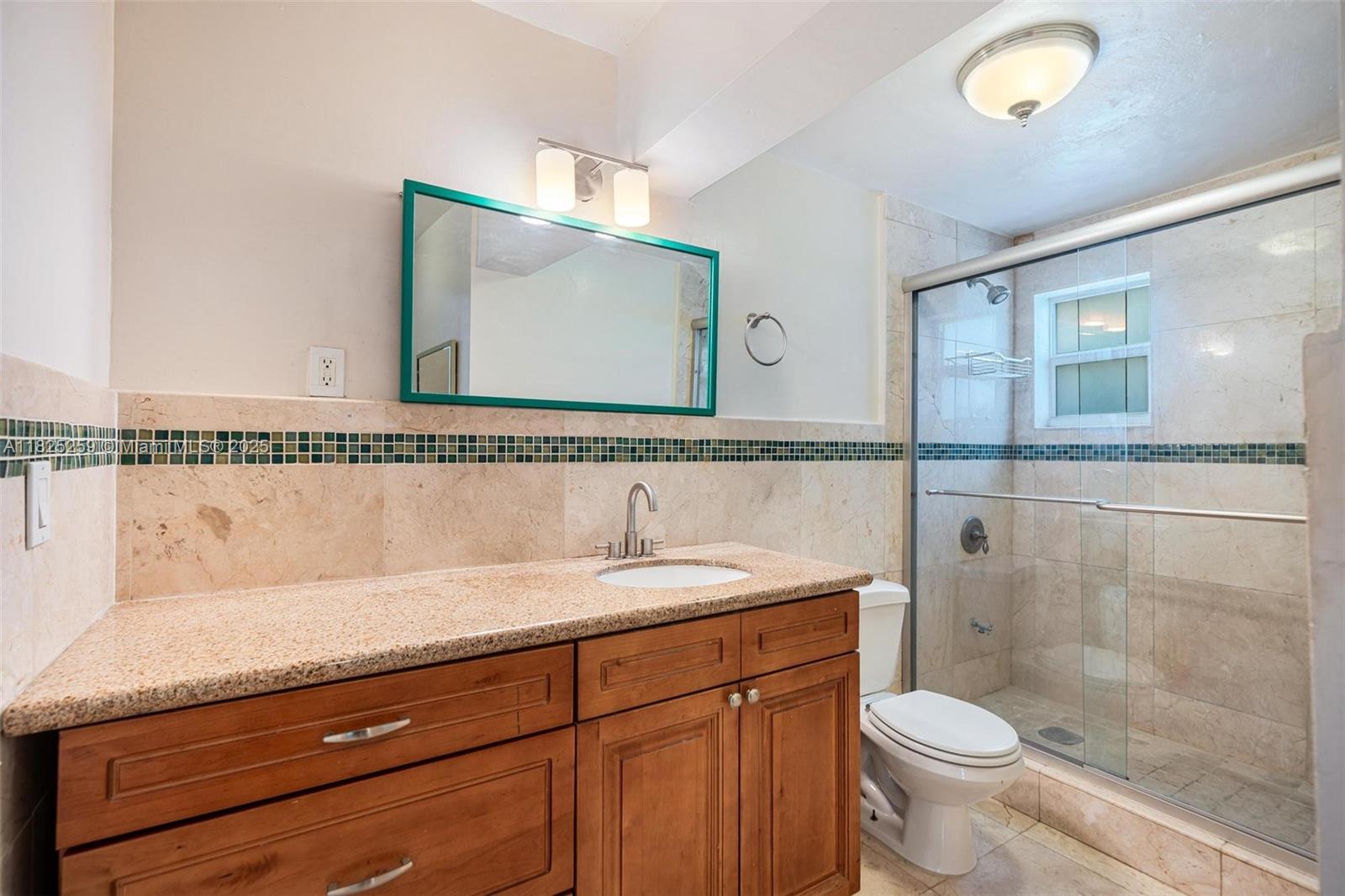 443 Southwest 18th Road Miami, FL 33129 - Photo 17 of 26 a bathroom with a granite countertop sink a toilet and a mirror