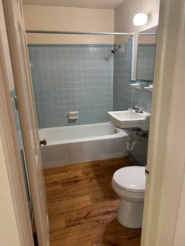 a bathroom with a sink a toilet a mirror and shower