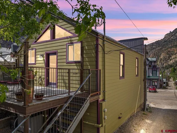 a view of a house with wooden fence and two windows