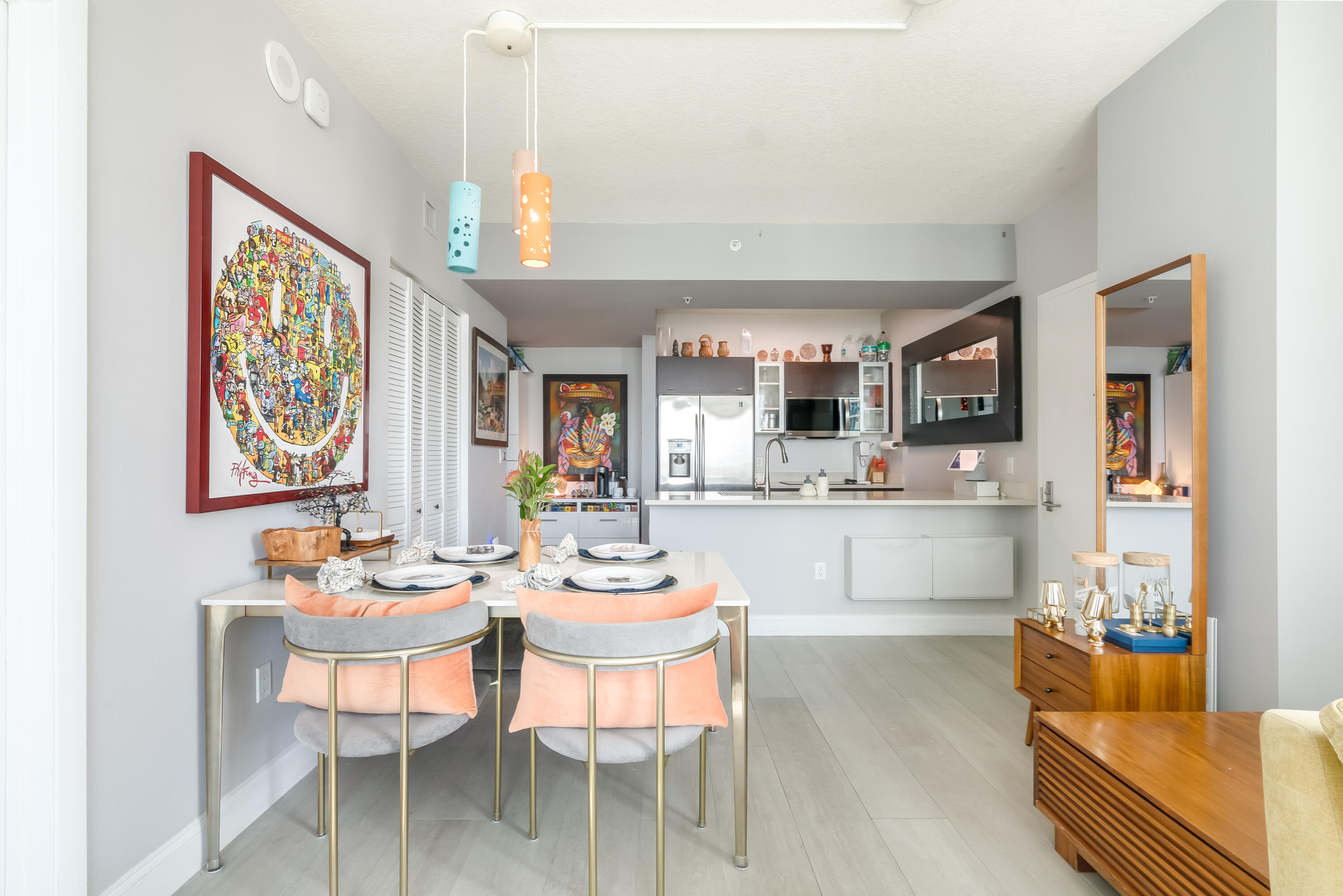 333 Northeast 24th Street, Unit 1102 Miami, FL 33137 - Photo 45 of 51 a dining room with wooden floor a chandelier fan a wooden table and chairs