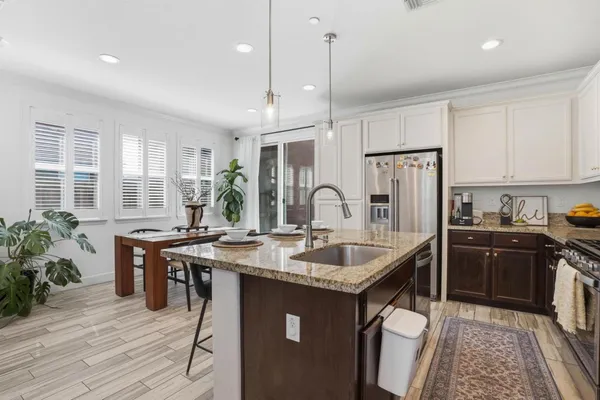 a kitchen with stainless steel appliances granite countertop a sink stove and refrigerator