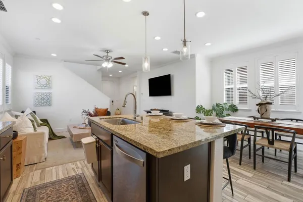 a view of kitchen island a sink and a flat screen tv