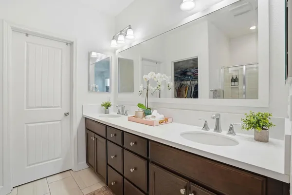 a bathroom with double sink and a mirror