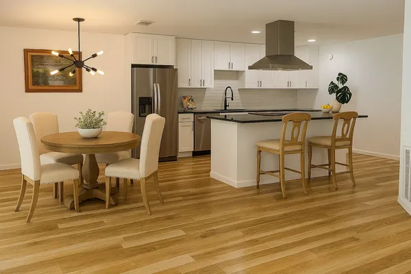 a kitchen with stainless steel appliances granite countertop a refrigerator a sink a stove and a wooden floors